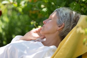 Older woman sleeping outside.